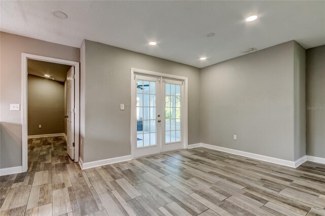 8330 Lafitte Dr, Hudson, FL 34667 - empty room featuring french doors, light wood-type flooring, baseboards, and recessed lighting