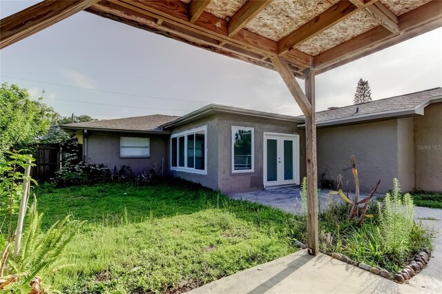 8330 Lafitte Dr, Hudson, FL 34667 - rear view of house with french doors, stucco siding, and a patio area
