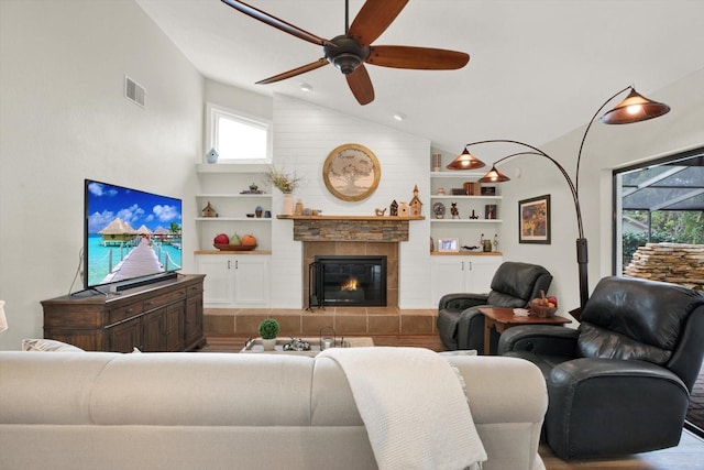 2806 Fairway View Dr, Valrico, FL 33596 - living area featuring vaulted ceiling, a ceiling fan, built in features, wood finished floors, and a tile fireplace