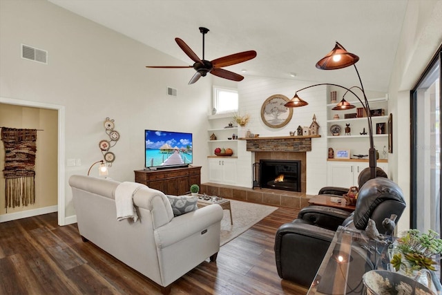 2806 Fairway View Dr, Valrico, FL 33596 - living area with a ceiling fan, a tiled fireplace, dark wood finished floors, high vaulted ceiling, and built in shelves