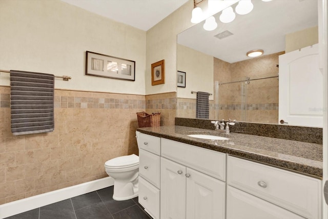 2806 Fairway View Dr, Valrico, FL 33596 - bathroom featuring tile walls, a shower stall, vanity, tile patterned flooring, and wainscoting