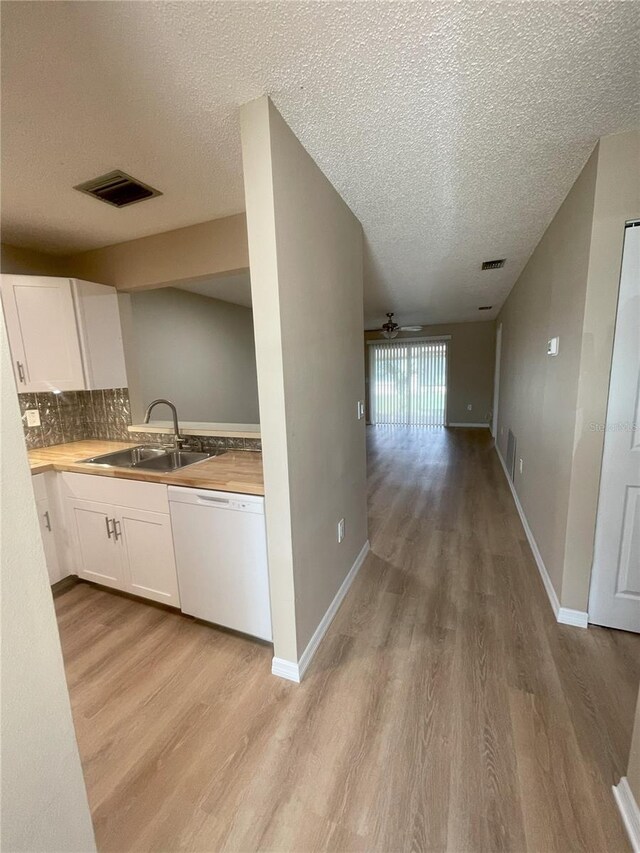 3007 Wainwright Ct, New Port Richey, FL 34655 - corridor featuring a sink, light wood-style flooring, a textured ceiling, and baseboards