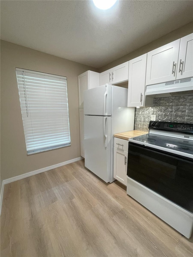 3007 Wainwright Ct, New Port Richey, FL 34655 - kitchen with range with electric cooktop, under cabinet range hood, freestanding refrigerator, light wood-type flooring, and decorative backsplash