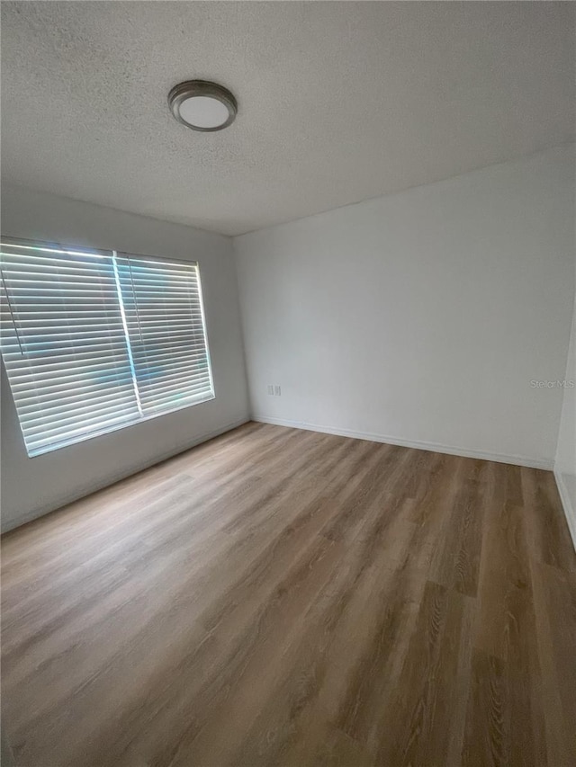 3007 Wainwright Ct, New Port Richey, FL 34655 - spare room with a textured ceiling, wood finished floors, and baseboards