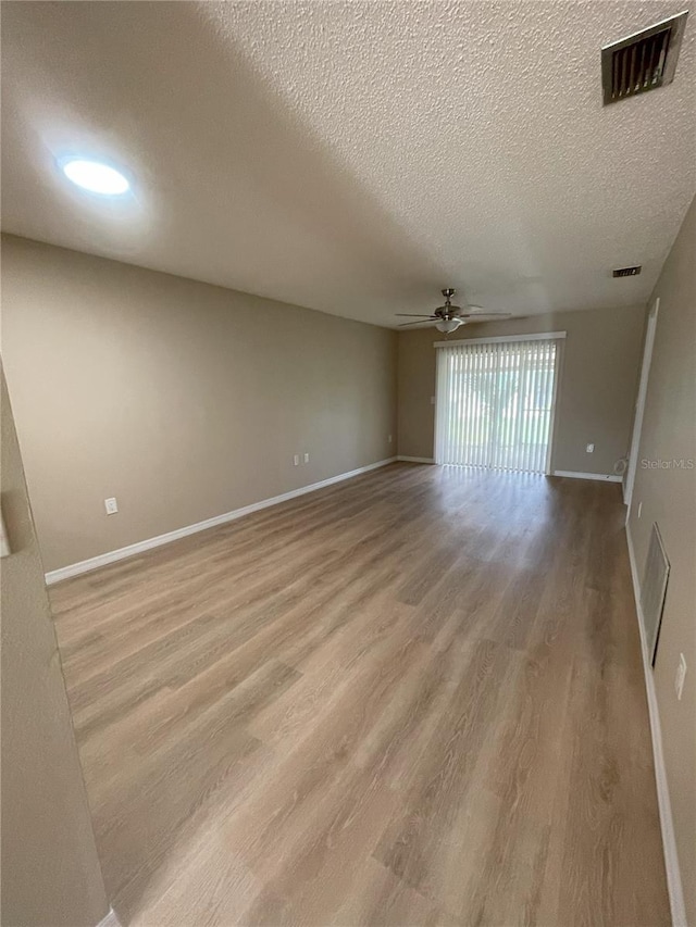 3007 Wainwright Ct, New Port Richey, FL 34655 - spare room featuring wood finished floors, a textured ceiling, a ceiling fan, and baseboards