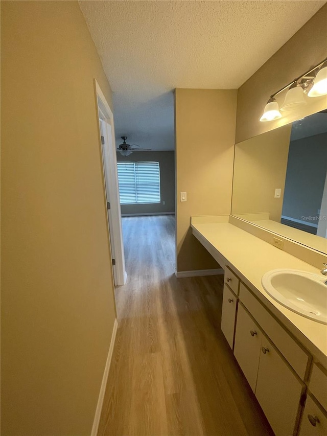 3007 Wainwright Ct, New Port Richey, FL 34655 - bathroom featuring wood finished floors, vanity, a textured ceiling, and baseboards