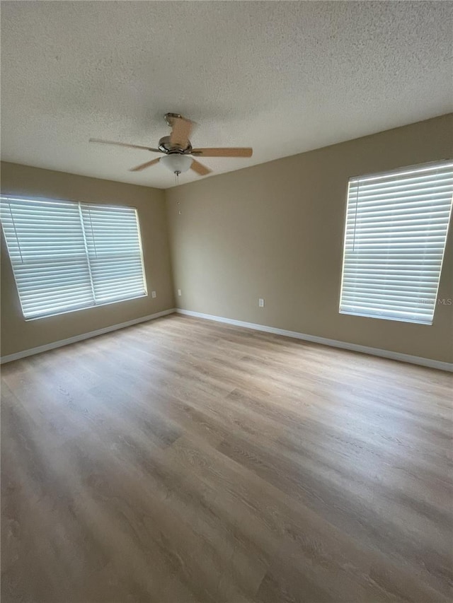 3007 Wainwright Ct, New Port Richey, FL 34655 - unfurnished room with a textured ceiling, wood finished floors, baseboards, and ceiling fan