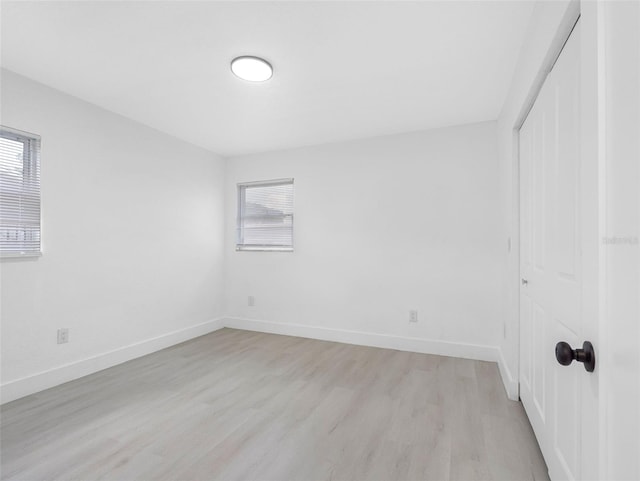 1213 W Camellia Dr, Brandon, FL 33510 - unfurnished bedroom featuring multiple windows, light wood-style flooring, a closet, and baseboards