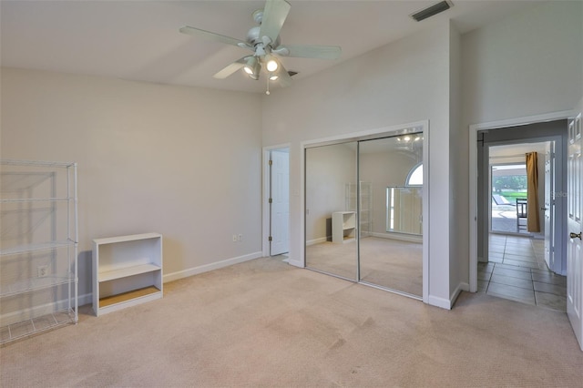 2021 Elk Spring Dr, Brandon, FL 33511 - unfurnished bedroom with carpet flooring, a closet, baseboards, a ceiling fan, and a towering ceiling