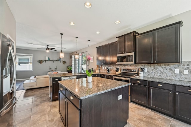 4151 Little Gap Loop, Ellenton, FL 34222 - kitchen featuring stainless steel appliances, a ceiling fan, backsplash, a peninsula, and a center island