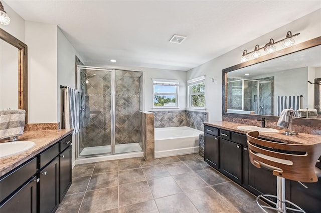 4151 Little Gap Loop, Ellenton, FL 34222 - bathroom featuring two vanities, a garden tub, a shower stall, and tile patterned floors
