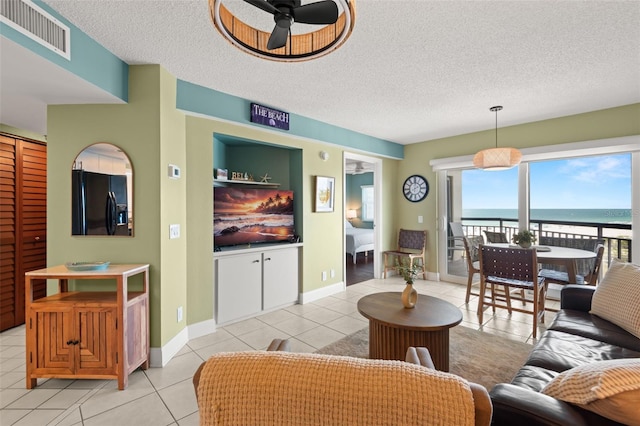 4510 Gulf Blvd Unit 604, St Pete Beach, FL 33706 - living area featuring light tile patterned floors, ceiling fan, and a textured ceiling