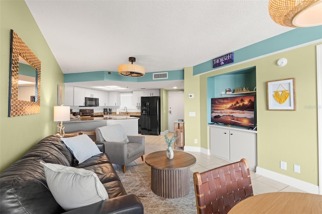 4510 Gulf Blvd Unit 604, St Pete Beach, FL 33706 - living room with light tile patterned flooring and a textured ceiling