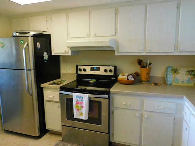 9 Forbes Pl Unit 310, Dunedin, FL 34698 - kitchen with appliances with stainless steel finishes, under cabinet range hood, light countertops, light tile patterned flooring, and white cabinets