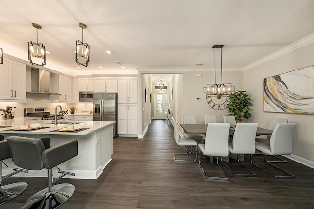 3318 Woodland Brook Way, Wesley Chapel, FL 33543 - kitchen featuring wall chimney exhaust hood, stainless steel appliances, ornamental molding, a chandelier, and a breakfast bar