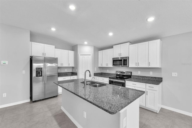 12907 Wildflower Meadow Dr, Riverview, FL 33579 - kitchen with stainless steel appliances, a sink, white cabinets, an island with sink, and dark stone countertops
