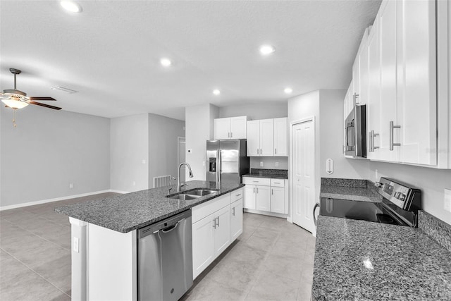 12907 Wildflower Meadow Dr, Riverview, FL 33579 - kitchen featuring stainless steel appliances, a sink, a ceiling fan, a center island with sink, and a textured ceiling