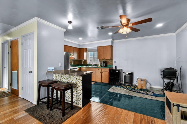 2501 18th Ave S, Saint Petersburg, FL 33712 - kitchen featuring a sink, ceiling fan, a peninsula, dark wood-style floors, and brown cabinets