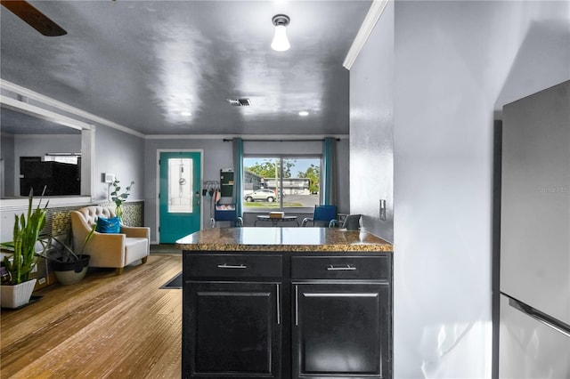 2501 18th Ave S, Saint Petersburg, FL 33712 - kitchen with dark cabinets, wood finished floors, crown molding, and a peninsula