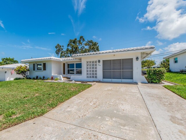 14045 90th Pl, Seminole, FL 33776 - single story home with stucco siding, a tile roof, a front lawn, and driveway
