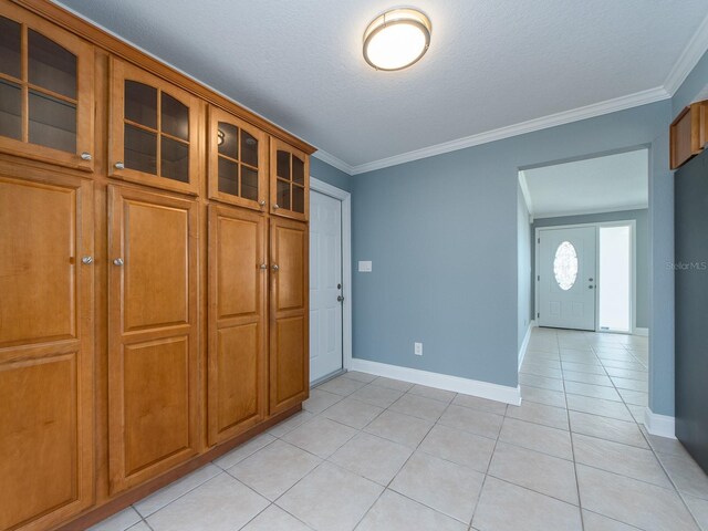 14045 90th Pl, Seminole, FL 33776 - unfurnished dining area featuring light tile patterned flooring, baseboards, crown molding, and a textured ceiling