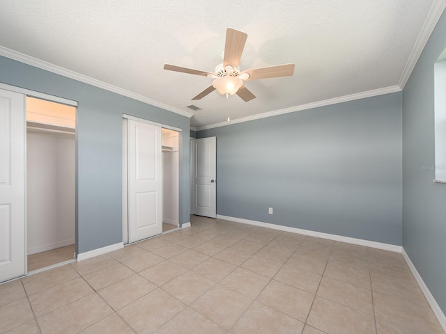 14045 90th Pl, Seminole, FL 33776 - unfurnished bedroom with two closets, crown molding, ceiling fan, baseboards, and light tile patterned floors