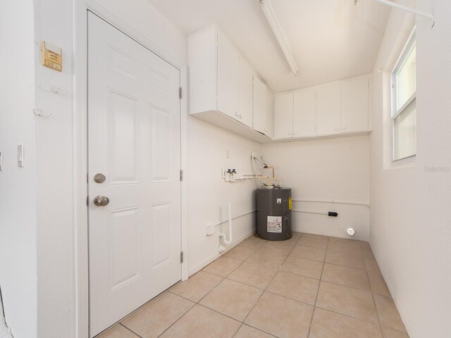 14045 90th Pl, Seminole, FL 33776 - laundry room with electric water heater, light tile patterned floors, and cabinet space