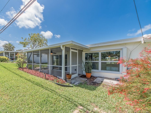 14045 90th Pl, Seminole, FL 33776 - rear view of property featuring a sunroom and a lawn
