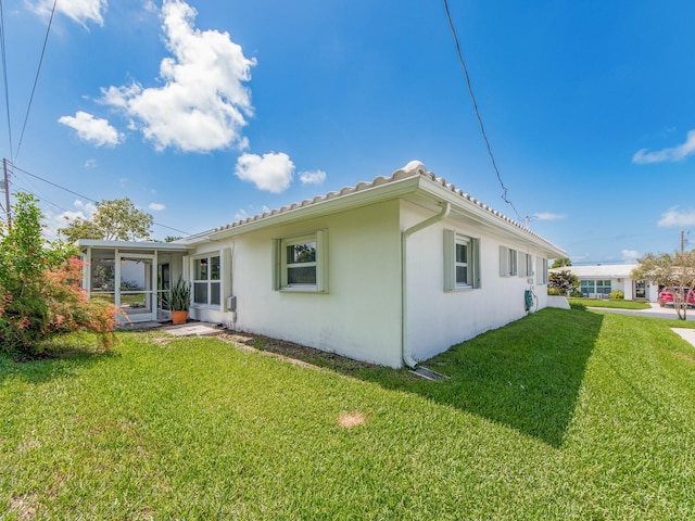 14045 90th Pl, Seminole, FL 33776 - back of property featuring a lawn, stucco siding, and a sunroom
