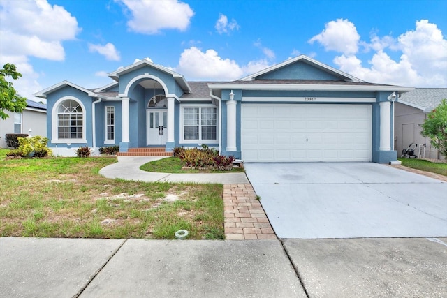 23917 Pow Wow Dr, Lutz, FL 33559 - single story home with stucco siding, an attached garage, driveway, a front lawn, and a porch