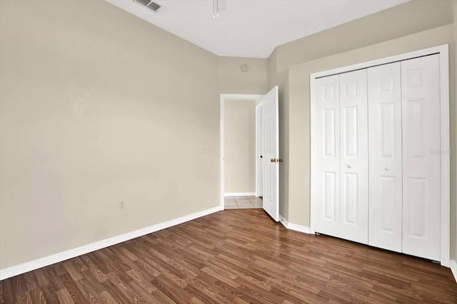 23917 Pow Wow Dr, Lutz, FL 33559 - unfurnished bedroom featuring wood finished floors, baseboards, and a closet