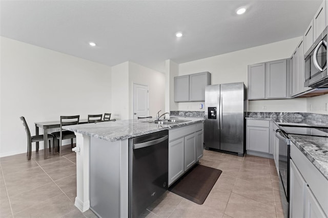 308 Mangrove Shade Cir, Apollo Beach, FL 33572 - kitchen with stainless steel appliances, gray cabinets, an island with sink, light tile patterned flooring, and recessed lighting