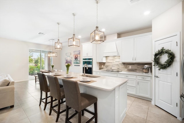 13157 Peachleaf Ave, Riverview, FL 33579 - kitchen with stainless steel double oven, a sink, decorative backsplash, light tile patterned floors, and a kitchen breakfast bar