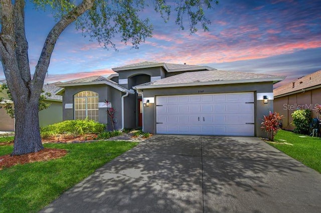31349 Philmar Ln, Wesley Chapel, FL 33543 - single story home with stucco siding, concrete driveway, an attached garage, and a lawn