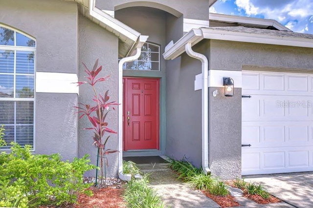 31349 Philmar Ln, Wesley Chapel, FL 33543 - view of exterior entry featuring stucco siding and an attached garage