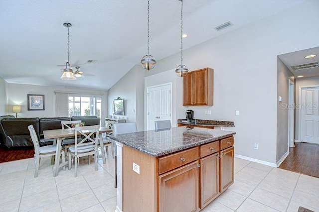 31349 Philmar Ln, Wesley Chapel, FL 33543 - kitchen with light tile patterned floors, a ceiling fan, vaulted ceiling, open floor plan, and dark stone counters