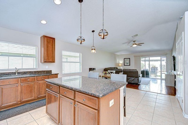 31349 Philmar Ln, Wesley Chapel, FL 33543 - kitchen with light tile patterned floors, healthy amount of natural light, a kitchen island, ceiling fan, and lofted ceiling