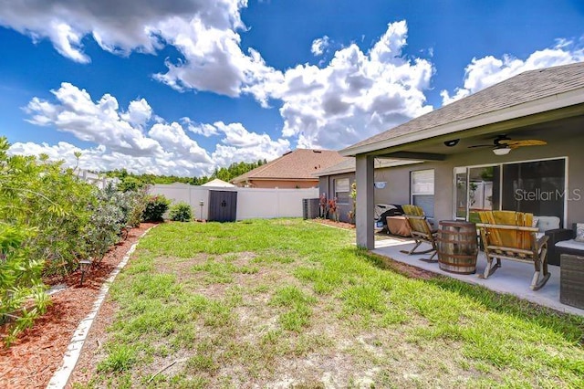 31349 Philmar Ln, Wesley Chapel, FL 33543 - fenced backyard featuring a ceiling fan, a patio area, an outdoor hangout area, and a storage shed
