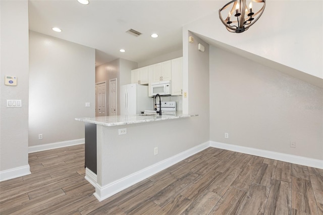 10966 Winter Crest Dr, Riverview, FL 33569 - kitchen featuring white appliances, light wood-style flooring, white cabinetry, a peninsula, and recessed lighting