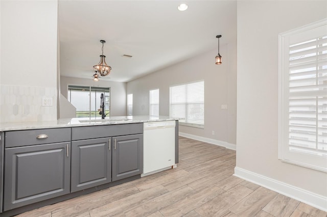 10966 Winter Crest Dr, Riverview, FL 33569 - kitchen with white dishwasher, gray cabinetry, a chandelier, light wood-type flooring, and hanging light fixtures