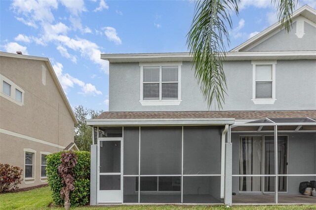 10966 Winter Crest Dr, Riverview, FL 33569 - back of house featuring a sunroom, a shingled roof, and stucco siding