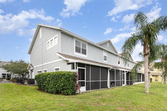 10966 Winter Crest Dr, Riverview, FL 33569 - back of house featuring a sunroom, stucco siding, and a lawn
