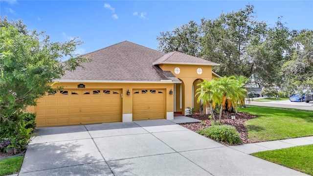3824 Duke Firth St, Land O Lakes, FL 34638 - traditional home featuring driveway, stucco siding, an attached garage, roof with shingles, and a front lawn