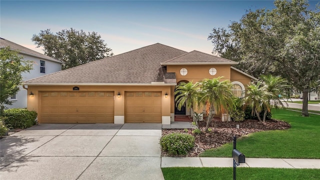 3824 Duke Firth St, Land O Lakes, FL 34638 - view of front of home with a garage, stucco siding, driveway, and roof with shingles