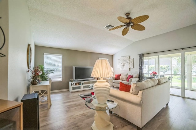 17567 SE 81st Parnassus Ct, The Villages, FL 32162 - living area featuring a textured ceiling, wood finished floors, a ceiling fan, lofted ceiling, and baseboards
