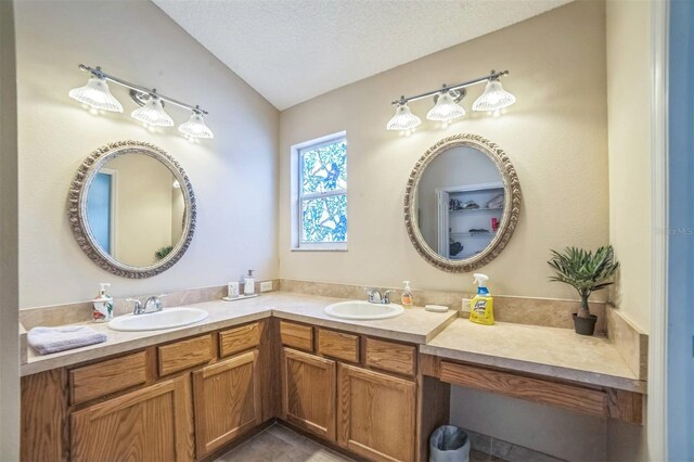17567 SE 81st Parnassus Ct, The Villages, FL 32162 - bathroom featuring double vanity, vaulted ceiling, and a textured ceiling