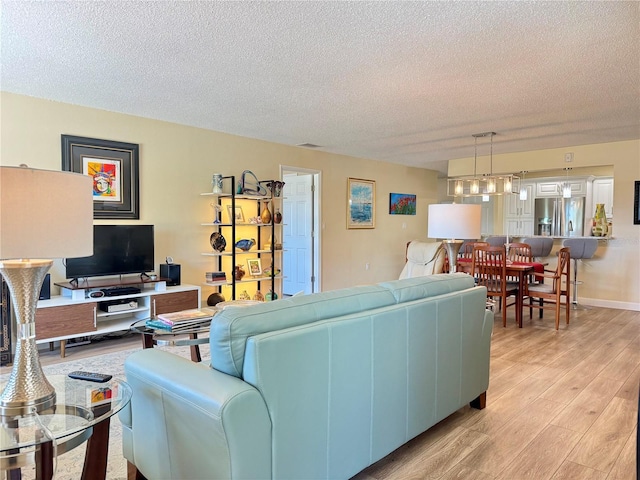 100 Bluff View Dr Unit 115C, Belleair Bluffs, FL 33770 - living area featuring a textured ceiling and light wood-type flooring