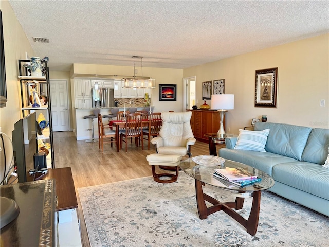 100 Bluff View Dr Unit 115C, Belleair Bluffs, FL 33770 - living room featuring light wood-style flooring and a textured ceiling