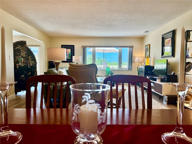 100 Bluff View Dr Unit 115C, Belleair Bluffs, FL 33770 - dining area with wood finished floors and a textured ceiling