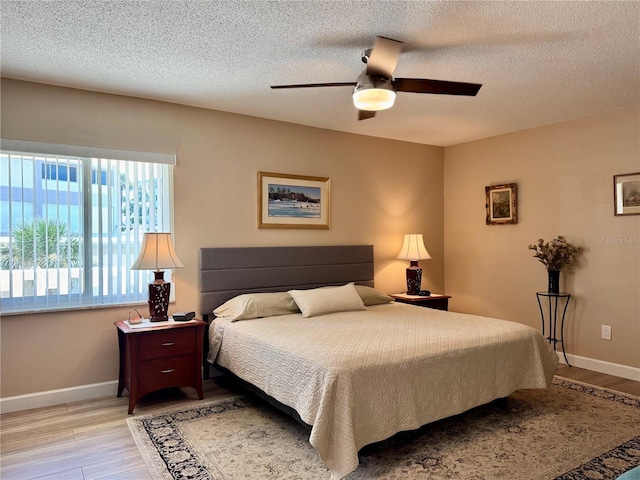 100 Bluff View Dr Unit 115C, Belleair Bluffs, FL 33770 - bedroom with light wood-style floors, a textured ceiling, and ceiling fan